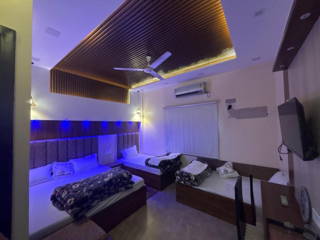 a living room with two beds and a tv at SEVEN SEVEN HOMESTAy in Amritsar