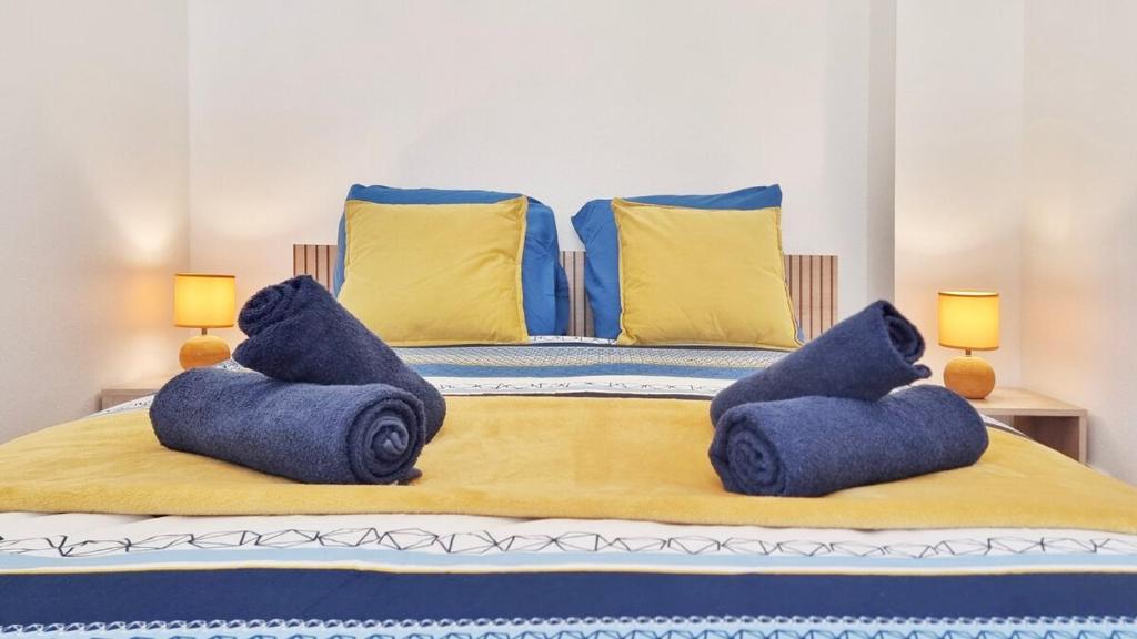 - un lit avec des serviettes bleues assises au-dessus dans l'établissement Chez Le General - Charmant T2, à Mulhouse