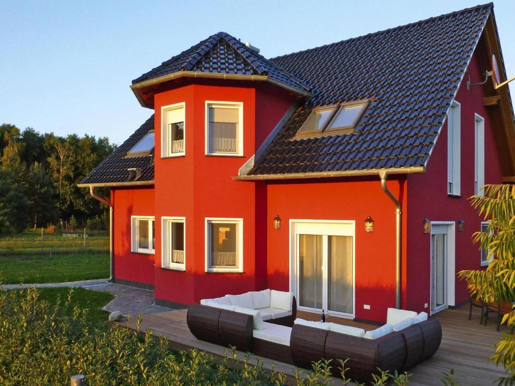 a red house with white furniture in front of it at Ferienhaus Zum roten Adler in Storkow in Storkow