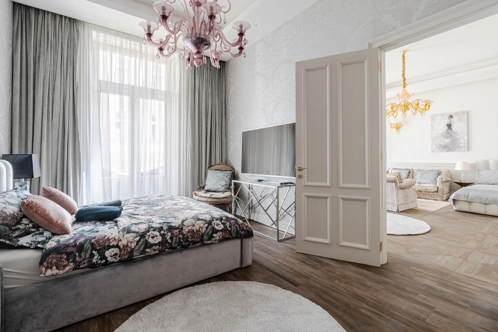 a bedroom with a bed and a chandelier at Basilica view prime apartment with free parking in Budapest