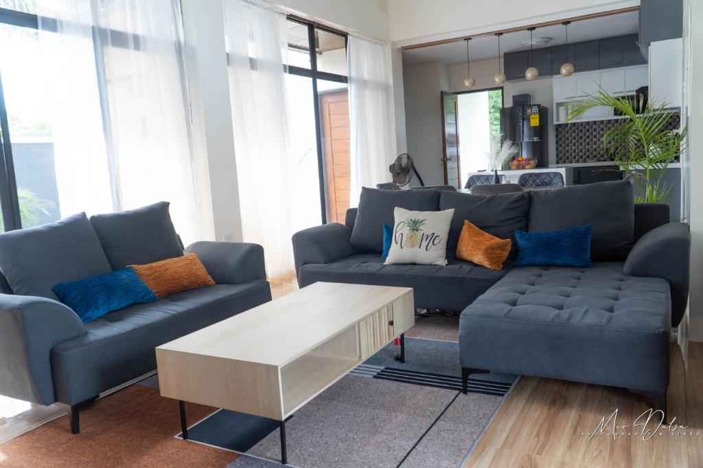 a living room with two couches and a coffee table at Gray Farmhouse in Buliwao