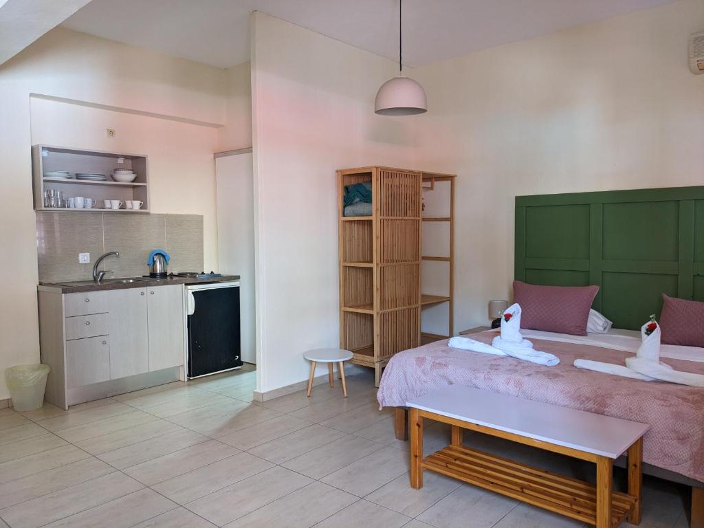 a bedroom with a bed and a kitchen with a sink at Pension Irene in Sougia