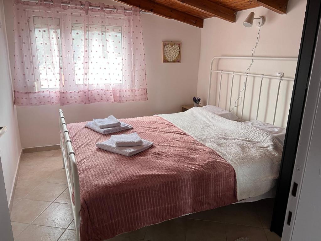 Un dormitorio con una cama con dos toallas encima. en Sweet Home Wooden, en Kastoria
