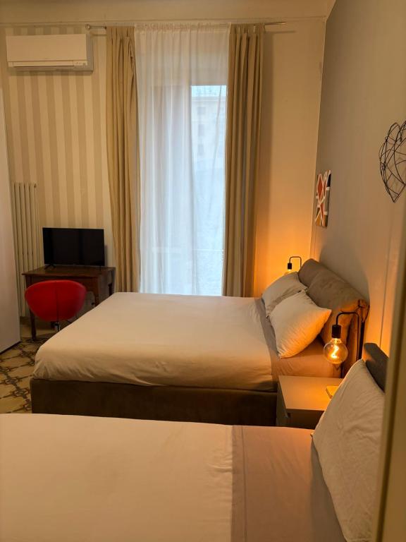 Una habitación de hotel con dos camas y una ventana. en Da Luis 5 Terre, en La Spezia
