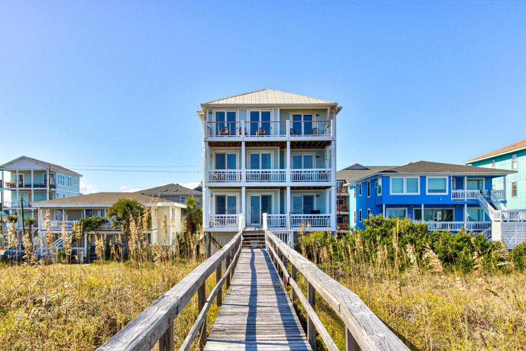 ein Haus auf einer Promenade vor einigen Häusern in der Unterkunft Ocean Oasis by Carolina Beach Realty in Carolina Beach