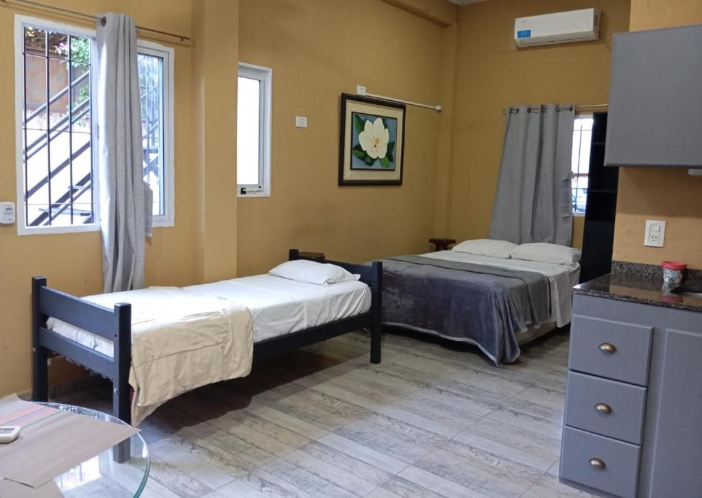 a room with two beds and a table and windows at DePTO ALTA GRACIA in Posadas