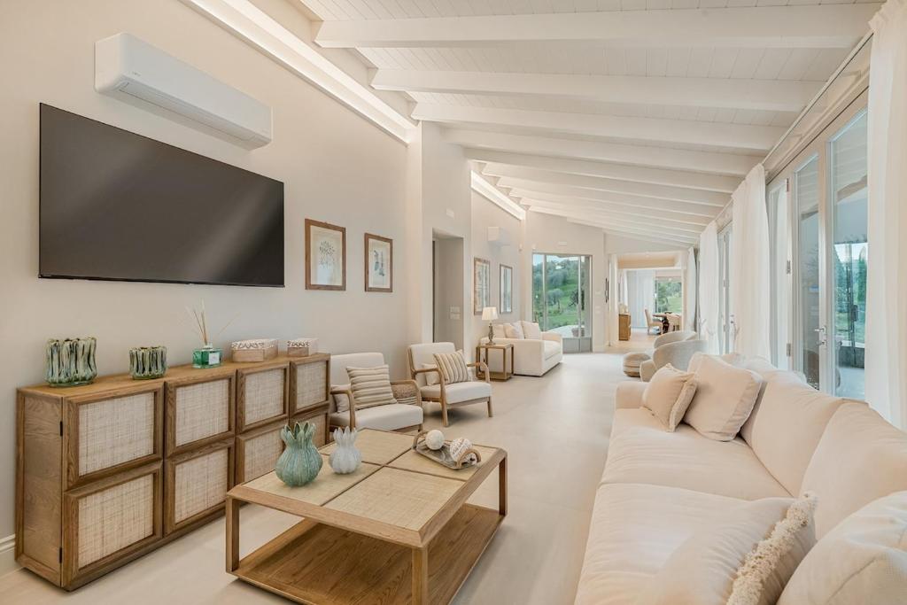 ein Wohnzimmer mit einem weißen Sofa und einem Fernseher in der Unterkunft GOLDEN LUXE - Diamond in the Hills piscina privata e vasca idromassaggio in Serravalle Pistoiese