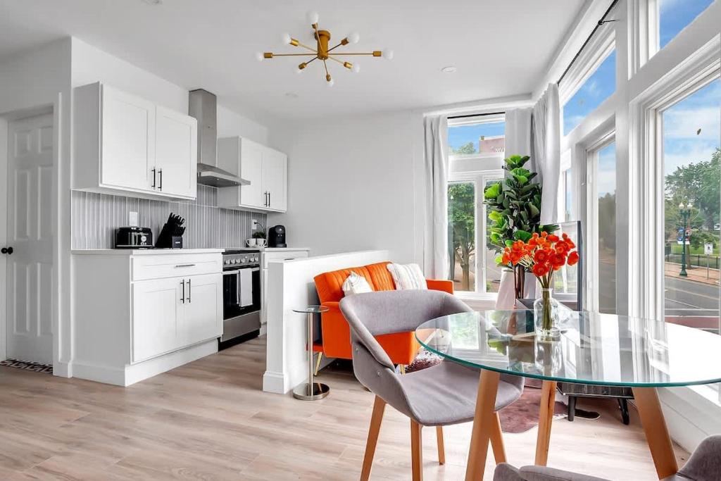 a kitchen and dining room with a glass table at Urban Nest #3 Bright loft steps to Proctors in Schenectady