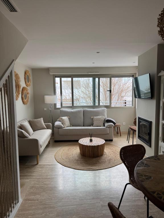 una sala de estar con un sofá y una mesa en Beautiful holiday duplex Vitania, en La Cala de Mijas