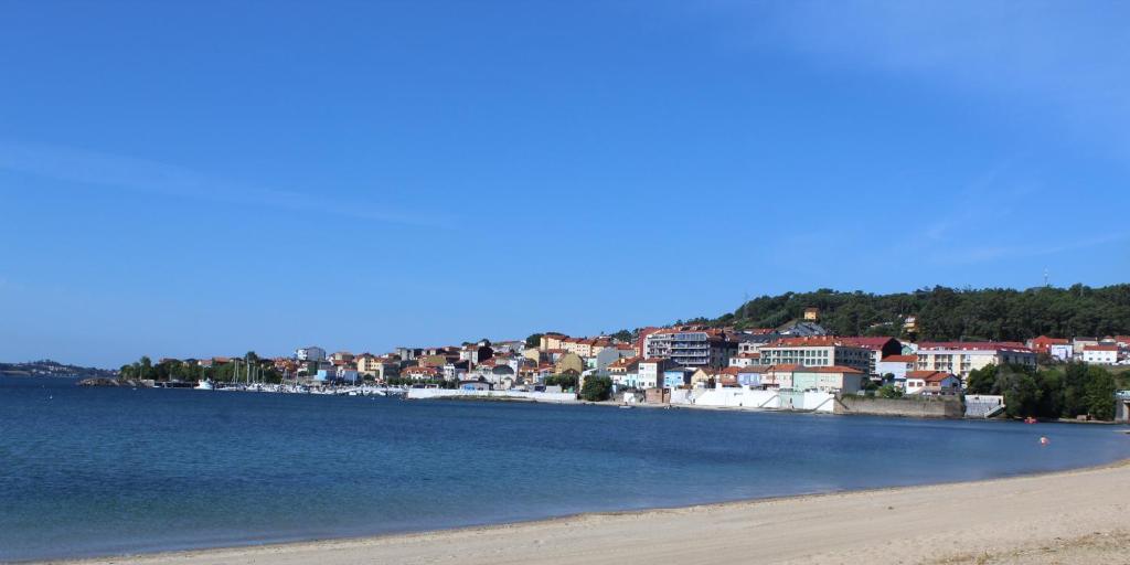 a view of a beach with a town in the background at Precioso apartamento en Boiro, Puerto de Escarabote in Magdalena