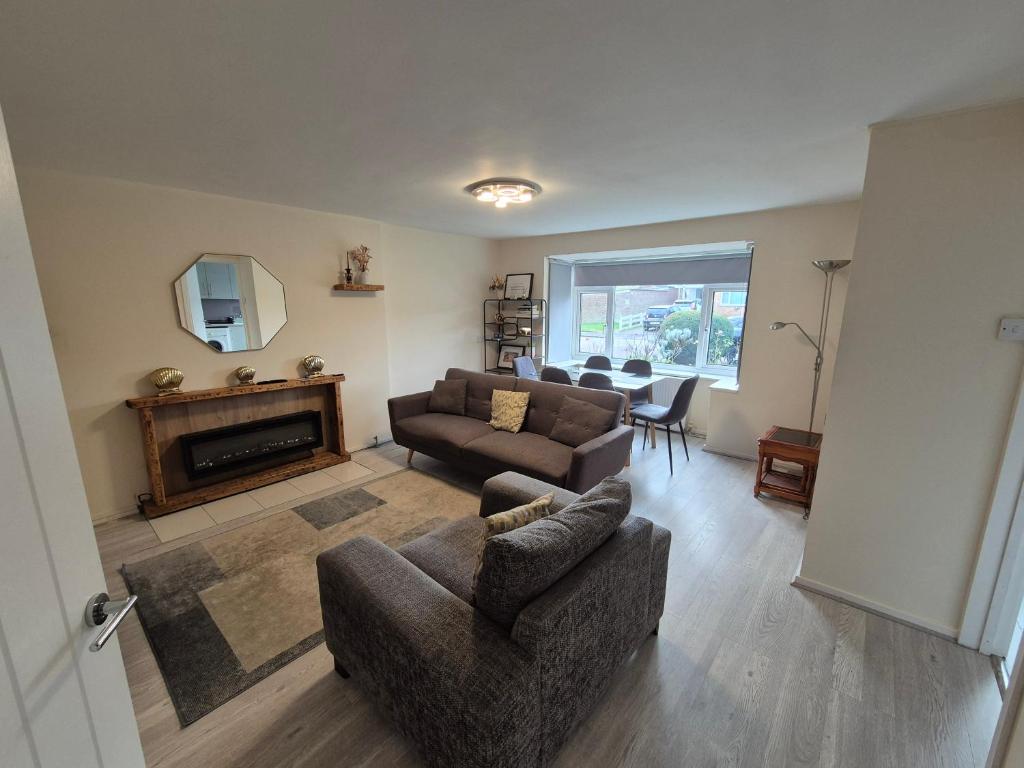 a living room with a couch and a fireplace at Cosy and Nice Apartment in Borehamwood