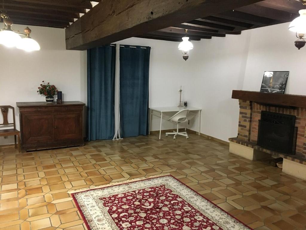 un salon avec une cheminée et une table dans l'établissement Maison entière Ibra, à Saint-Agil