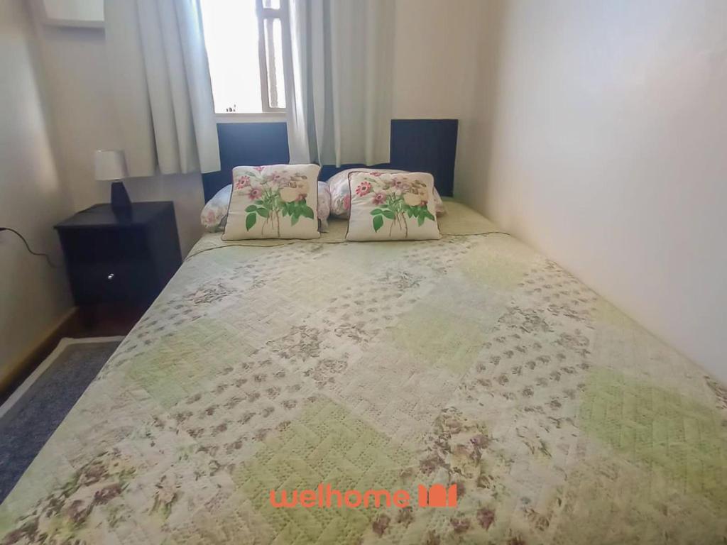 a bed with two pillows on it in a bedroom at Cobertura com Vista e Conforto no RS in Santo Ângelo