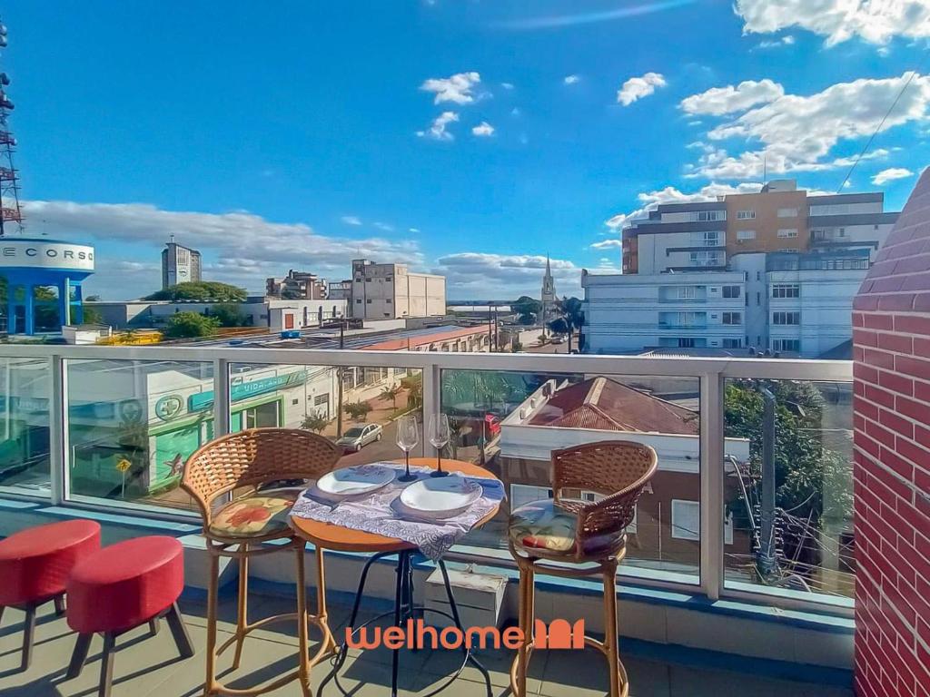 a balcony with a table and chairs and a view of a city at Cobertura com Vista e Conforto no RS in Santo Ângelo