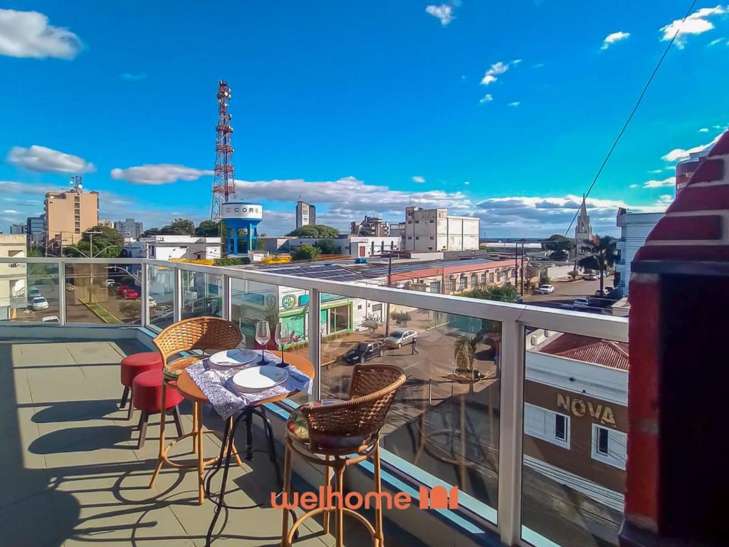 a balcony with tables and chairs and a view of a city at Cobertura com Vista e Conforto no RS in Santo Ângelo