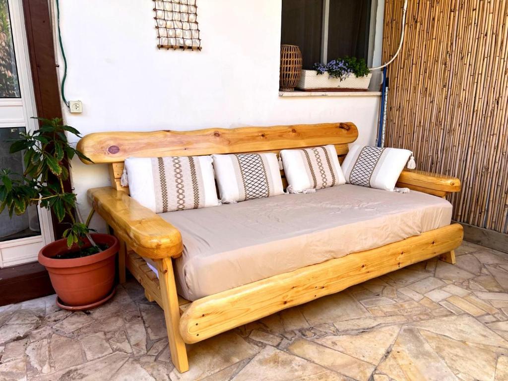 a wooden bed with pillows on a patio at Unique Suite In Eilat in Eilat