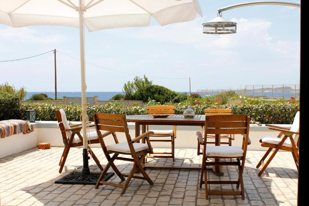 una mesa y sillas con una sombrilla en el patio en Villa Penelope - Marathopoli, en Marathopolis