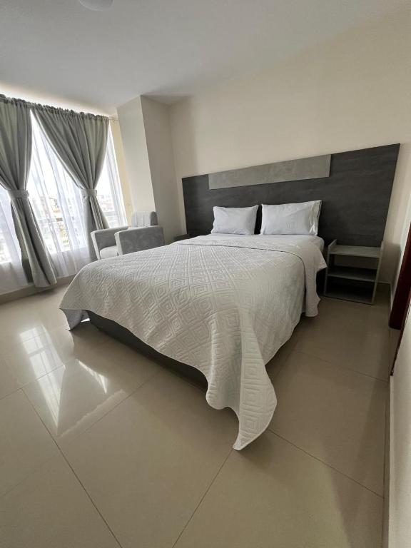 イピアレスにあるHotel Iberia Plazaのベッドルーム1室(大型ベッド1台、白い掛け布団付)