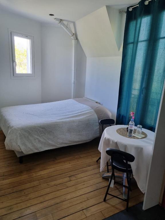une chambre avec un lit et une table avec des chaises dans l'établissement Bohemian cosy flat, à Paris