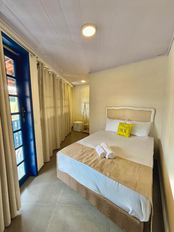 a bedroom with a bed with a yellow pillow on it at Suíte Céu in Congonhas