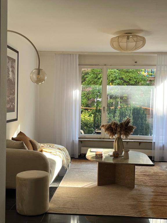 a living room with a couch and a table and a window at Cozy Central Apartment in Basel