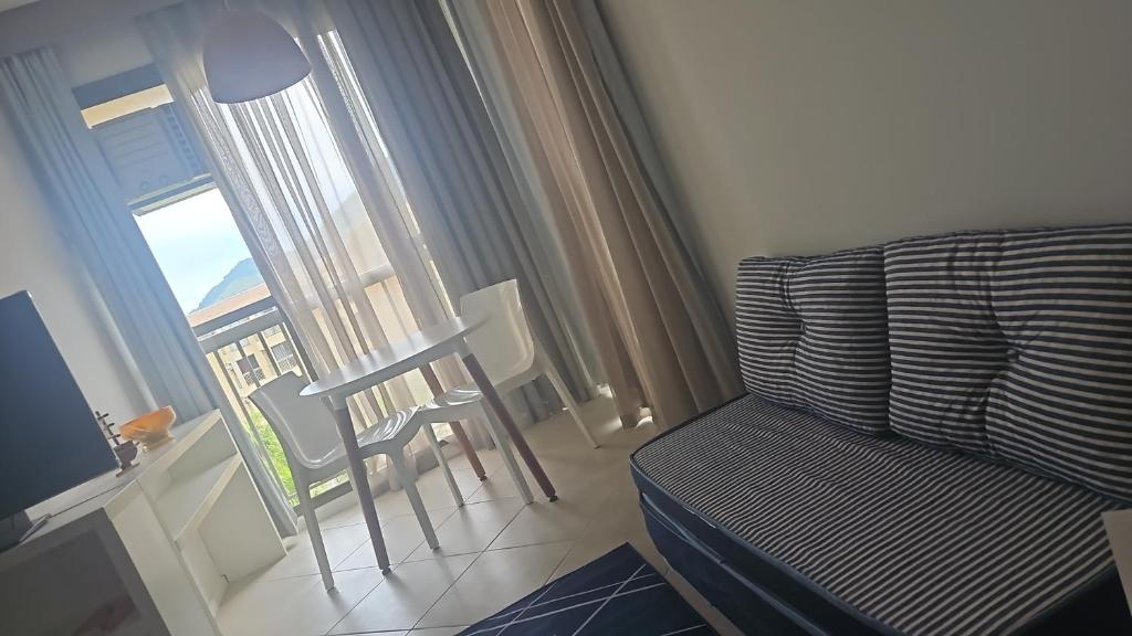 a living room with a couch and a window at Loft Reserva do Sahy in Mangaratiba