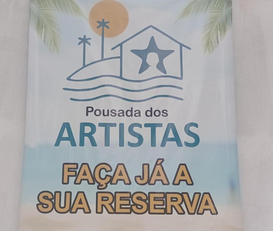 a sign for a resort on the beach at Pousada dos Artistas in Japaratinga