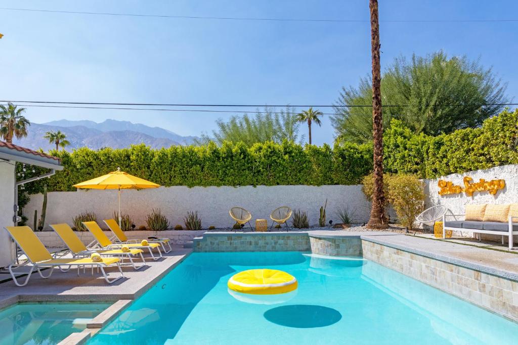Una piscina con sillas y un juguete amarillo en el medio. en Lemon Twist by ACME House Company, en Palm Springs