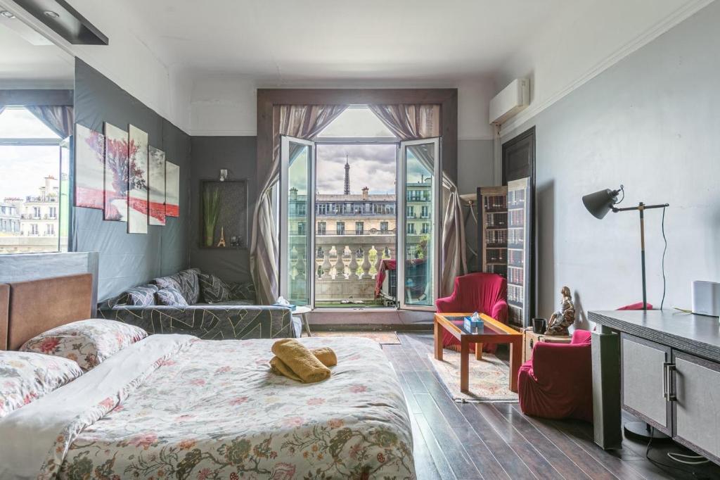 une chambre avec un lit et une grande fenêtre dans l'établissement Élysées vip, à Paris