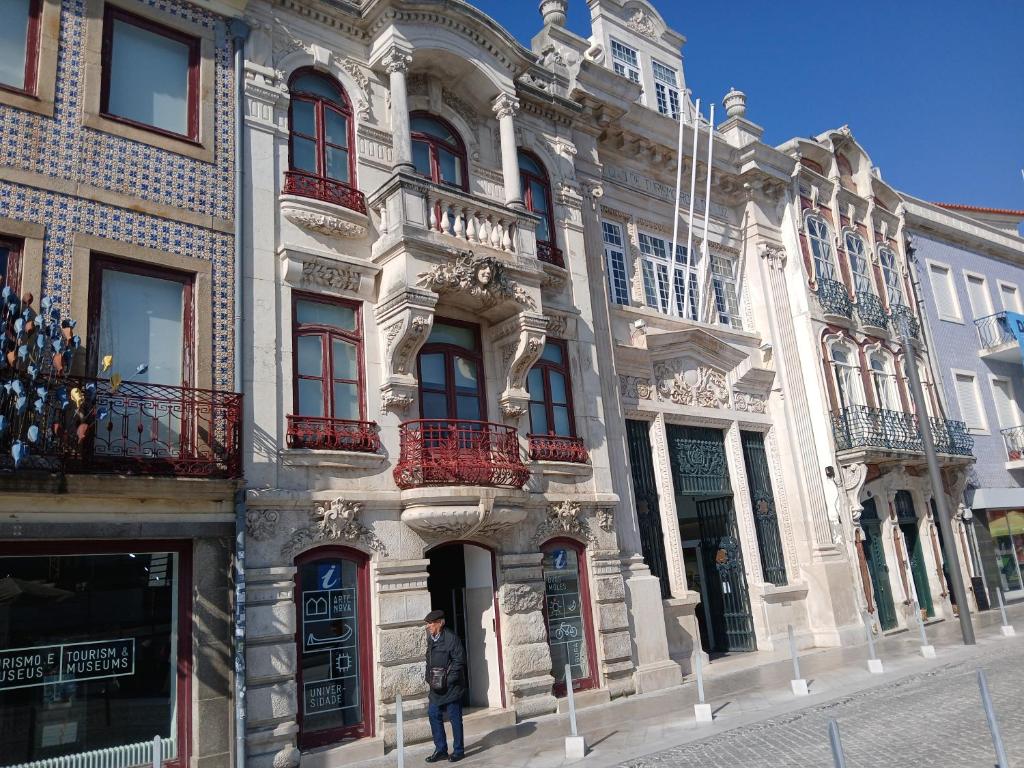 une personne se tient devant un bâtiment dans l'établissement Ria apartments, à Aveiro
