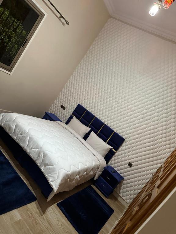 a bedroom with a white bed with blue pillows at Villa haut standig 2000 m2 in Marrakesh