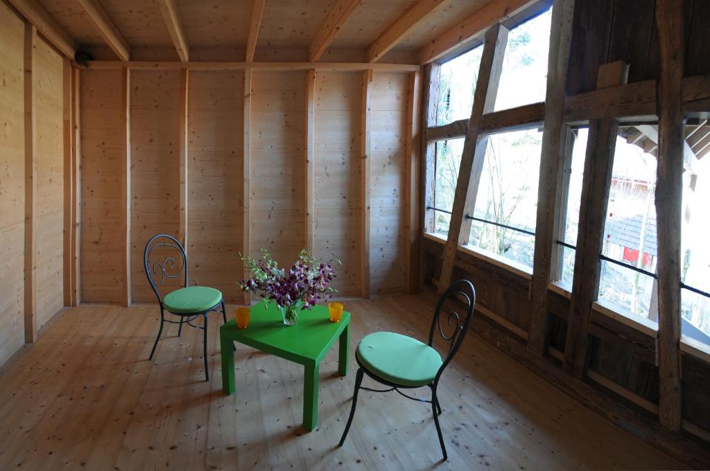 a room with two chairs and a table with flowers on it at Bed and Breakfast Wegmann in Andelfingen