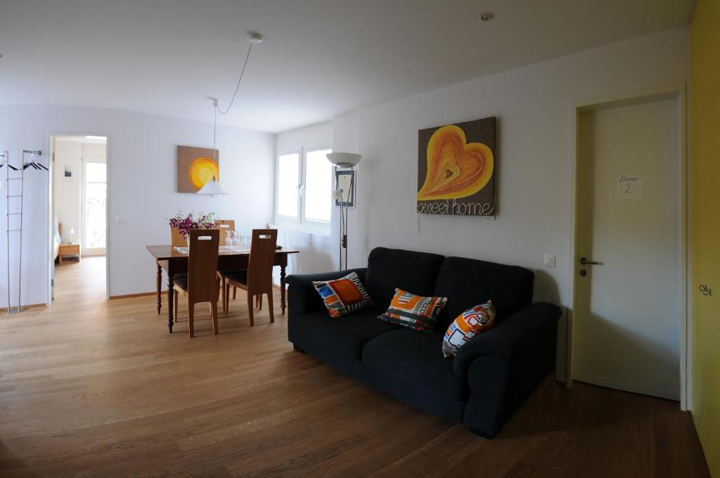 a living room with a couch and a dining room at Bed and Breakfast Wegmann in Andelfingen
