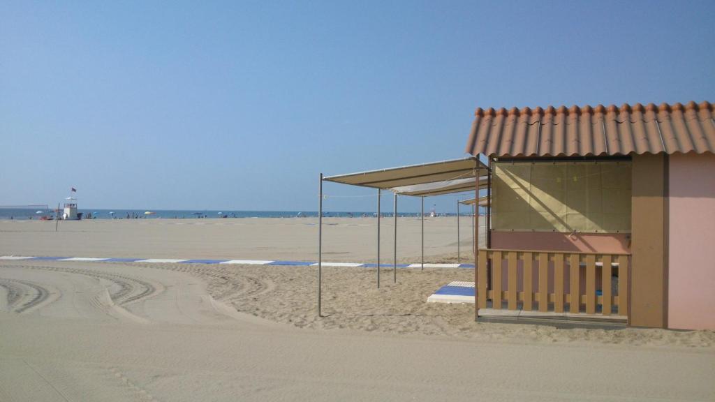 una fermata dell'autobus su una spiaggia con un edificio di B&B Tra Mare e Laguna a Lido di Venezia