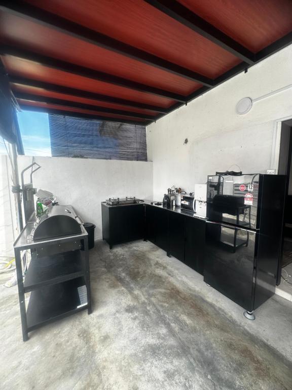 a kitchen with black cabinets and a red ceiling at Tepi Villa Private Pool PD in Port Dickson