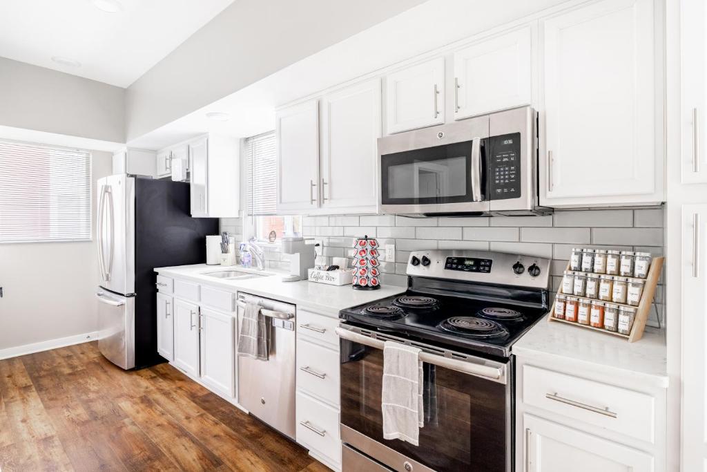 a kitchen with white cabinets and a stove top oven at Luxury Downtown Townhome Private Garage Unit 11 in Cleveland