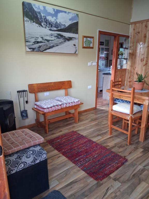 a living room with two benches and a table at Cabaña Tranquila in Villarrica