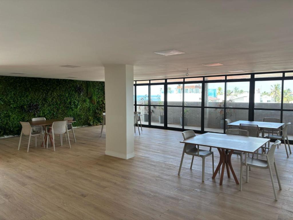 イポジュカにあるOra Beach Residenceのテーブルと椅子、窓が備わる空き部屋