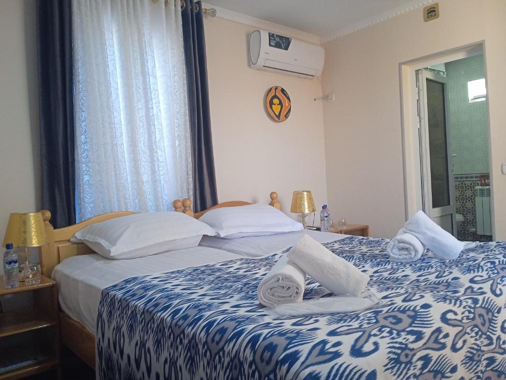 una camera da letto con un letto con asciugamani sopra di Guest House AN With Free Out of City Tour a Bukhara