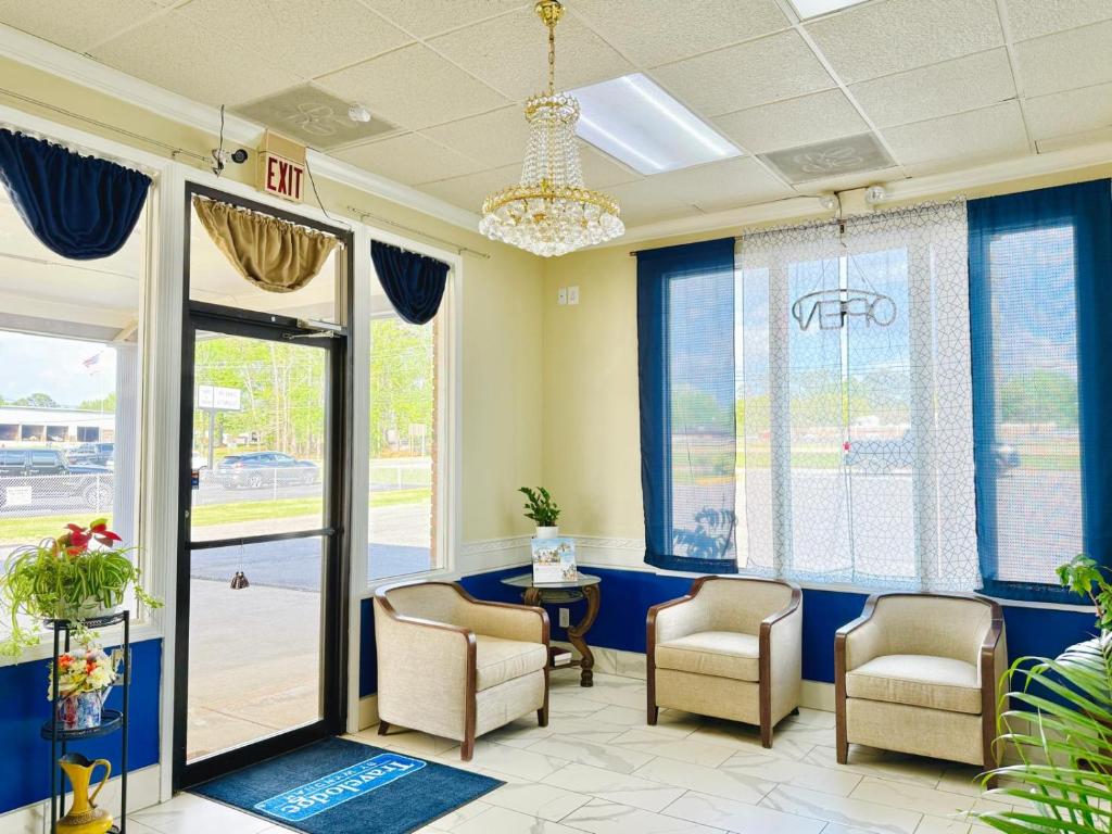 a waiting room with chairs and a table and windows at Travelodge by Wyndham-Thomasville AL in Thomasville