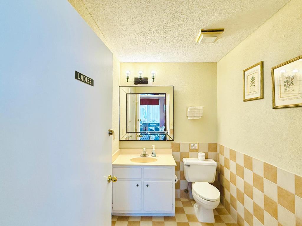 a bathroom with a toilet and a sink and a mirror at Travelodge by Wyndham-Thomasville AL in Thomasville