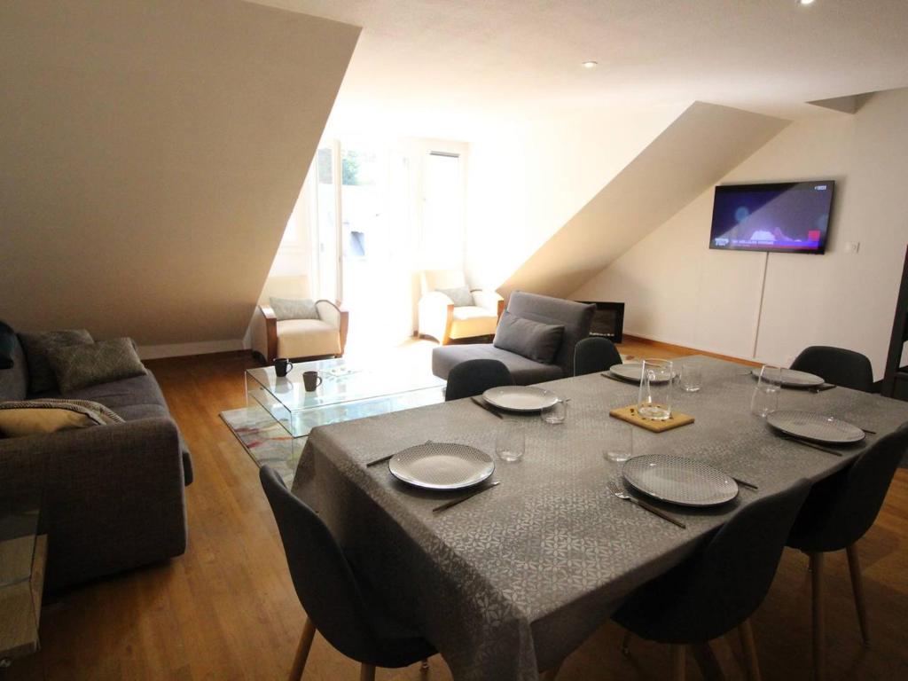 - un salon doté d'une table avec des assiettes et des verres à vin dans l'établissement Élégant T3 Duplex avec Ascenseur à Luchon, Parking et Wifi - FR-1-313-242, à Luchon