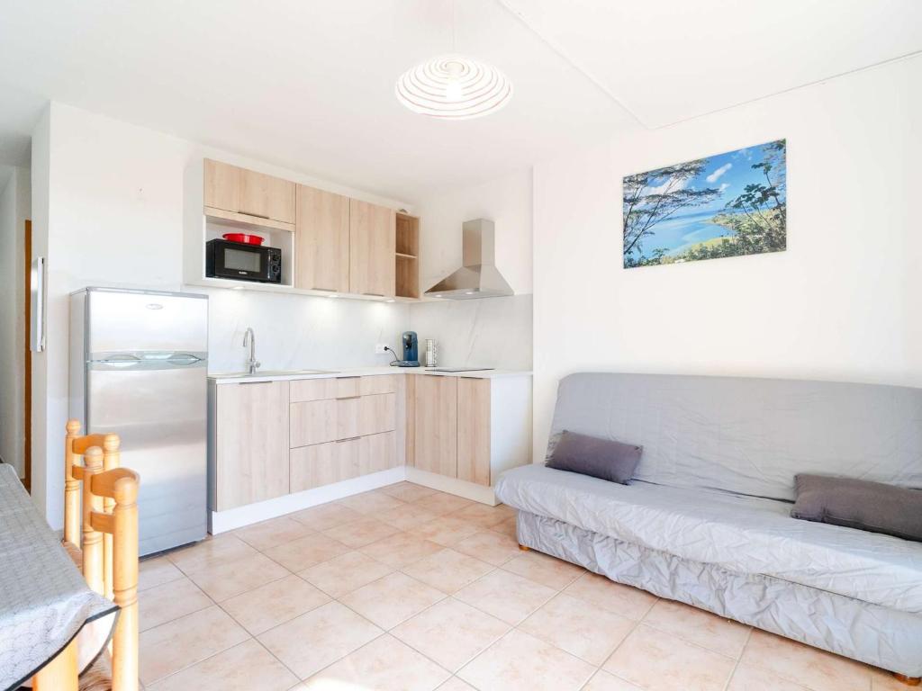 un salon avec un canapé et une cuisine dans l'établissement Appartement T2 avec Wifi, Animaux admis et Parking à Saint-Pierre-La-Mer - FR-1-409-280, à Fleury