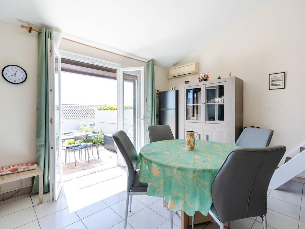 une cuisine et une salle à manger avec une table et des chaises dans l'établissement Villa T2 avec mezzanine, Wi-Fi, climatisation, animaux admis, parking, pour 4 personnes - FR-1-409A-34, à Gruissan