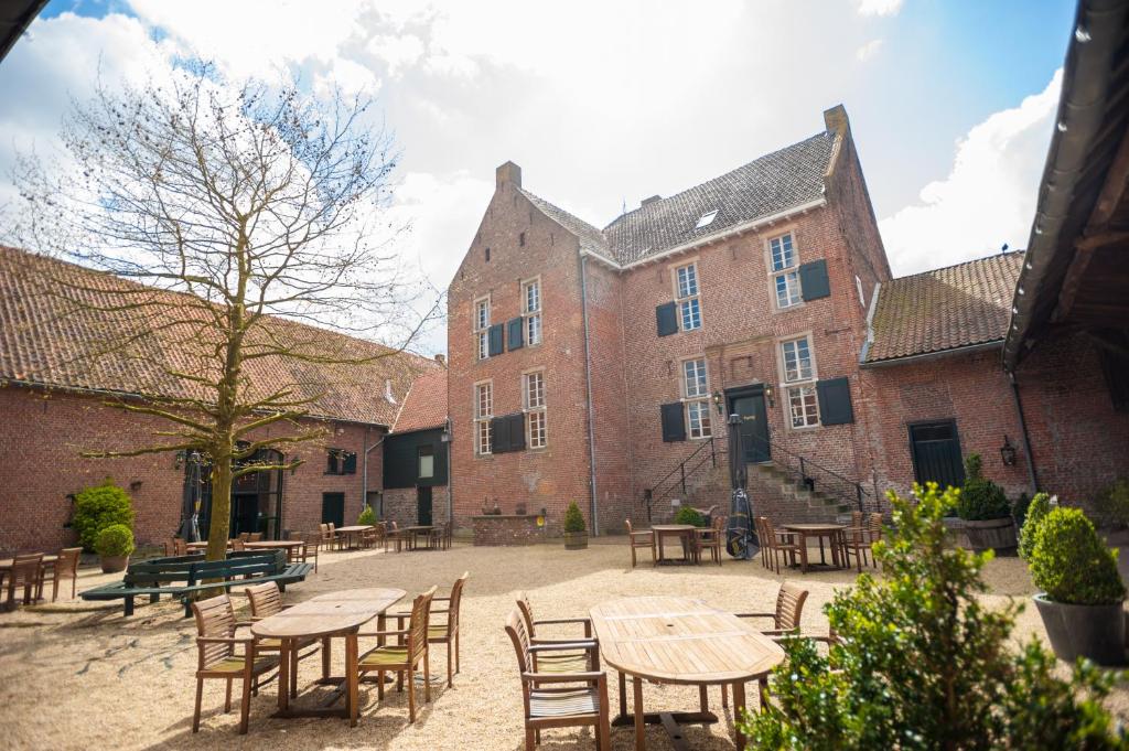 a courtyard with tables and chairs in front of a building at Hotel Schinvelder Hoeve in Schinveld