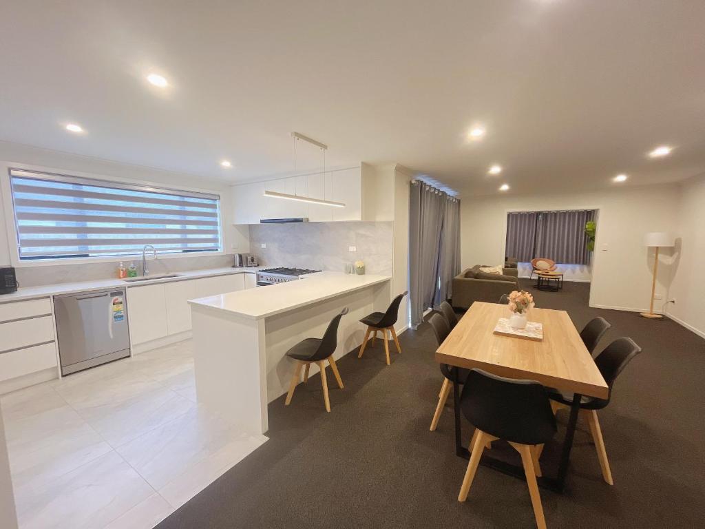 eine Küche und ein Esszimmer mit Tisch und Stühlen in der Unterkunft Rotorua Sunshine Brand New 4 Bedroom house in Rotorua