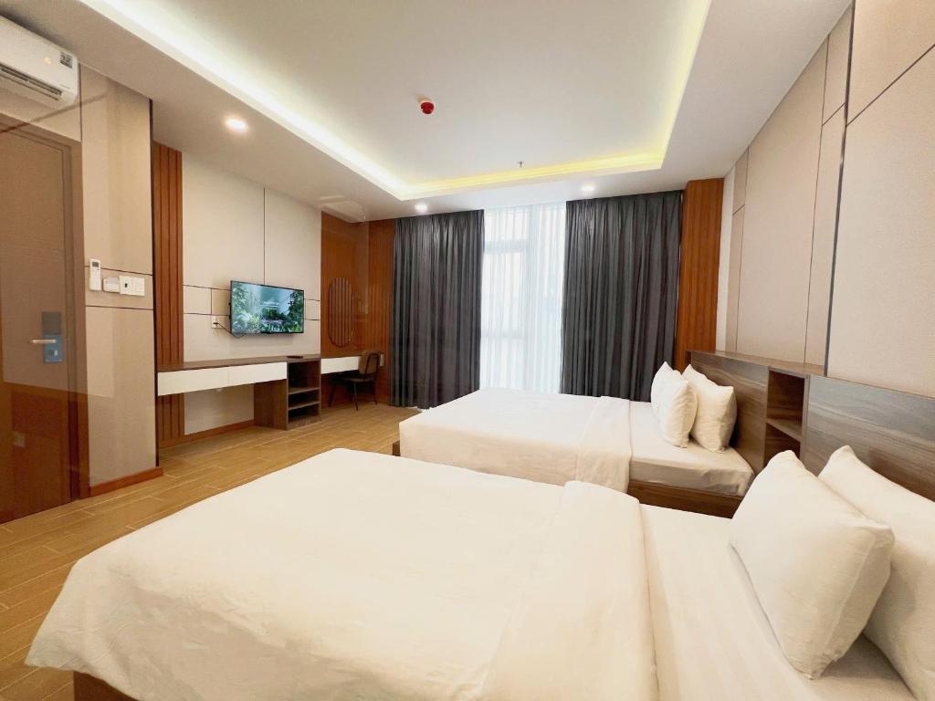 ホーチミン・シティにあるK&T Hotel Sân Bay TSN-150m từ Nhà Ga T3のベッド2台と薄型テレビ付きのホテルの部屋