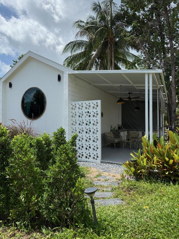a white house with a large window on the side of it at High-In Holiday Home&Villa in Ko Phangan