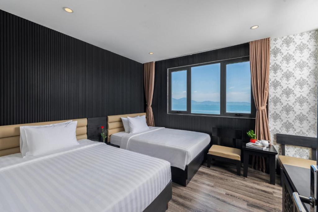 A twin room with two beds and a broad window overlooking the sea.
