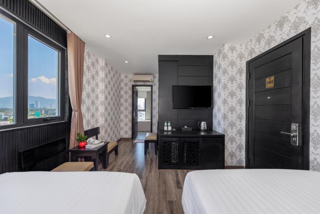 A twin room with two beds, television, storage cabinet and a city-and-mountain view.